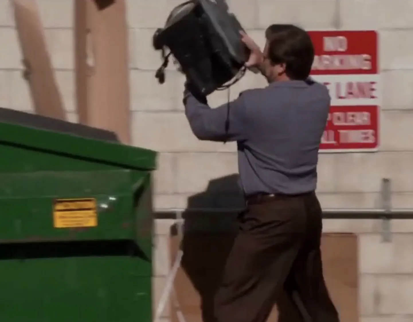 Man throwing computer in trash 