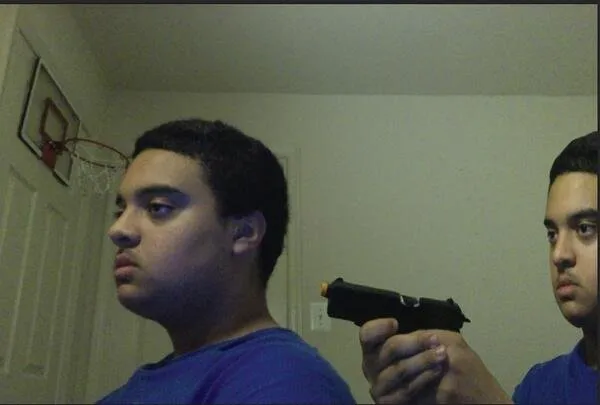 guy pointing gun at self 