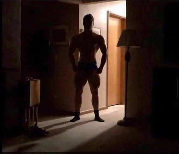 shadowy buff guy in a doorway 